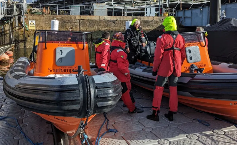 Course instructor and participants looking at 2 powerboats