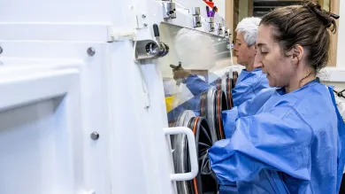 Staff using containment protection equipment