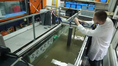 A researcher doing a flume Experiment on Scour around offshore wind turbine monopile