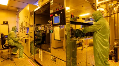 Researchers wearing cleanroom suits usin the deep ultraviolet (DUV) scanner facility