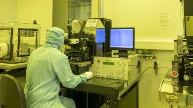 Integrated Photonics Cleanroom - a researcher in a cleanroom suit uses the Karl Zuss MA6 contact aligner