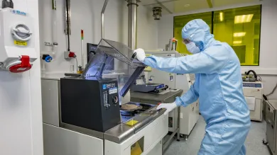 A person in a uniform working at Disco DAD341 wafer saw