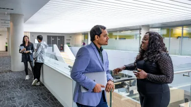 Students chatting on a balcony overlooking the MBA suite