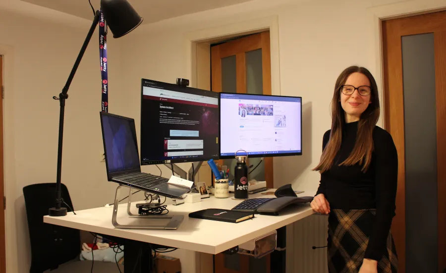 Elizabeth Gardiner standing for a photo next to a dual monitor computer set-up.