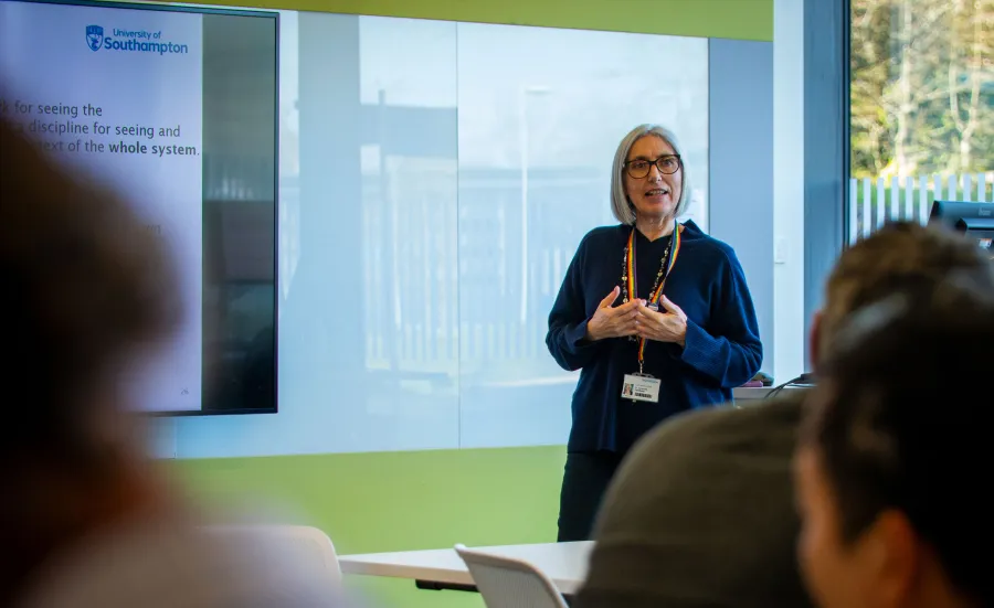 The course lead, Jeni Giambona, stood at the front of a classroom leading a session.