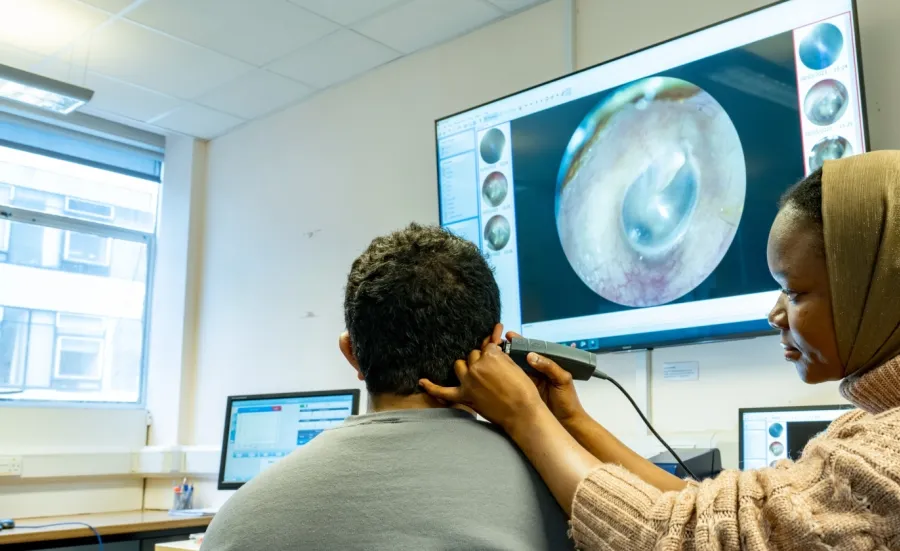 A student examines a patient in a clinical project using video otoscopy
