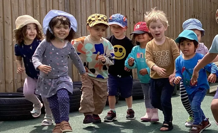 Children running in a playground at the Early Years Centre