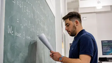 picture of someone writing a maths equation on a blackboard