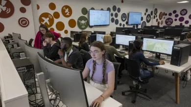 A computer lab with students working on desktop computers