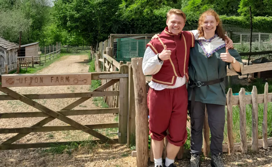 Krzysztof and Joanna standing next to a gate wearing medieval costume