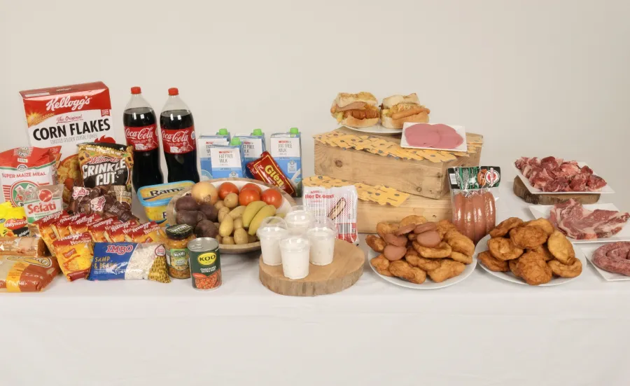 A table displaying a wide range of foods, including fresh produce, dairy, packaged snacks, and raw meats.
