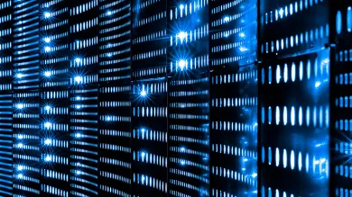 Rows of illuminated server racks with a blue glow, in a data centre, representing digital infrastructure that powers AI and data analysis.