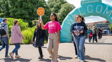 A student leading a campus tour at a university open day.
