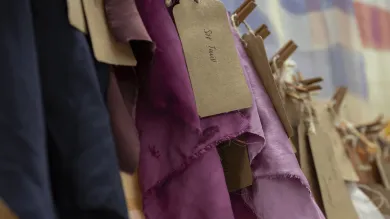 Different purple fabrics on a rack in a textiles studio