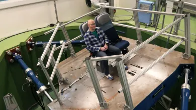 Six-axis motion simulator with aircraft-style seating used for vibration and motion research in the VibSim laboratory
