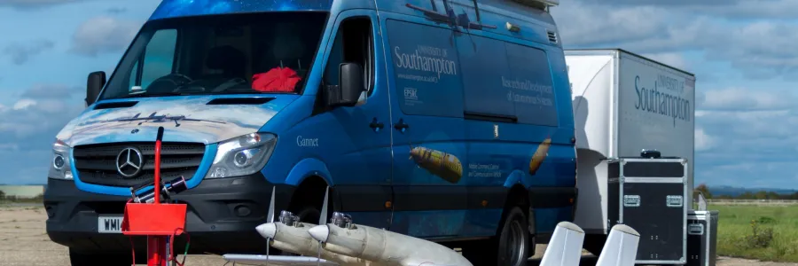 Blue van with University of Southampton branding and a small drone in front, parked near a white trailer and black storage cases.