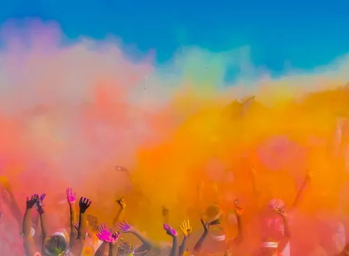 Group of people throwing coloured powder in the air