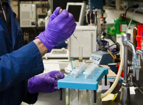 A scientist injects a test tube with fluid