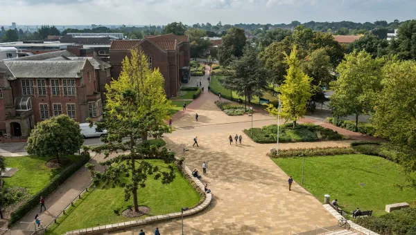 Aerial view of campus buildings, trees and courtyard area on a sunny day.