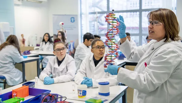 School children in lab coats learning in the Life Lab.