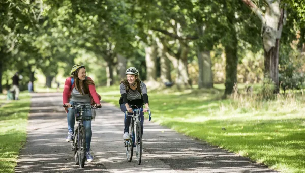 Students cycling on Southampton Common on sunny day.