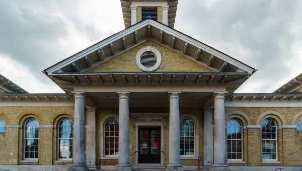 Exterior view of impressive stone building with columns and canopy.