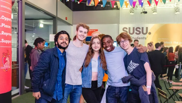 Group of smiling students at SUSU event.