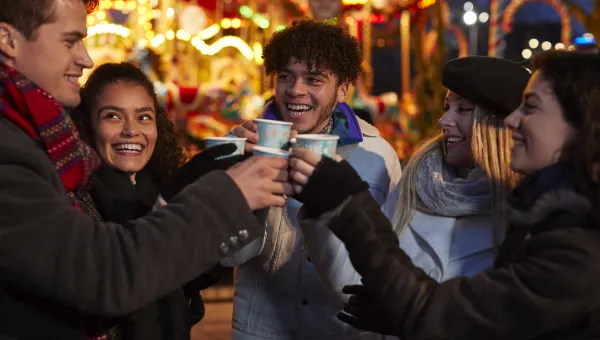 Group of friends saying cheers at a christmas market. 