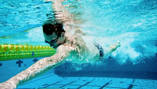 Man swimming under water in a swimming pool.