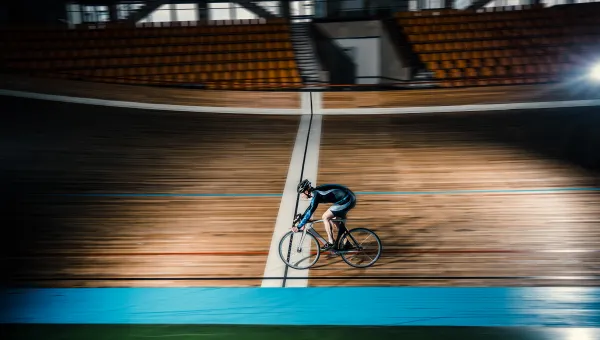 Cyclist moving fast on indoor velodrome. 
