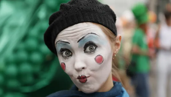 Close up of lady made up as a clown, wearing a woollen beret. 