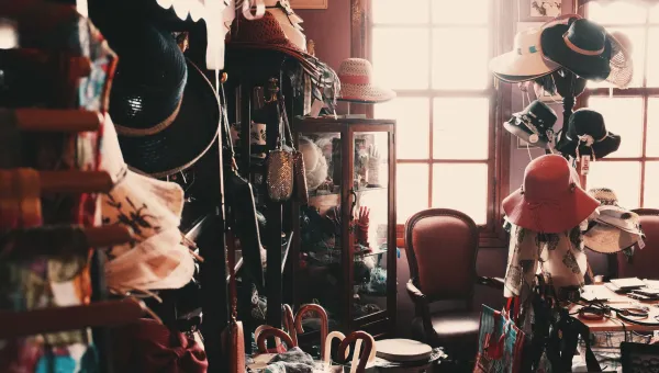 Clothes, hats and scarves on display inside a vintage clothes shop. 