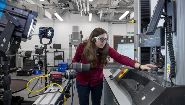 Student adjusting machinery in the Testing Structures Research Laboratory. 