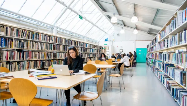 Students studying at desks in the Winchester School of Art library.
