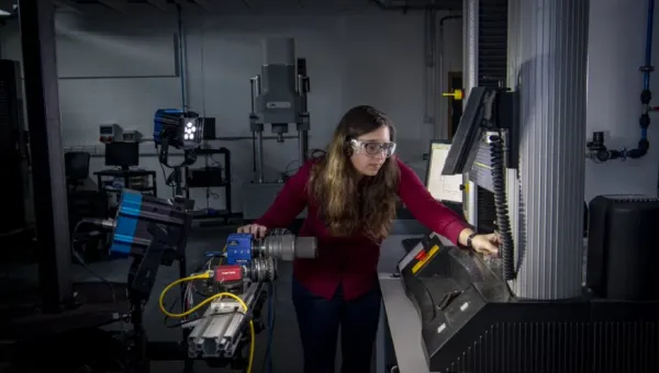 A student uses a piece of equipment in the testing and structures research lab