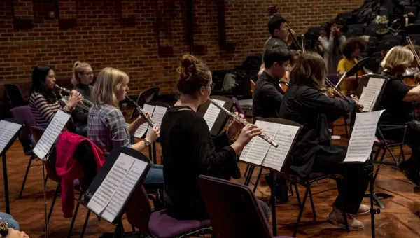 Music students playing strings and brass perform live in Turner Sims concert hall