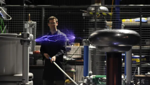 A researcher conducting an electrical experiment in the high voltage lab.