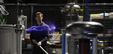 A researcher conducting an electrical experiment in the high voltage lab.