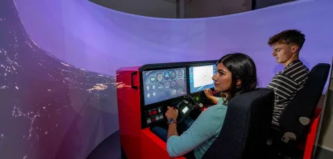 2 students use the flight simulator