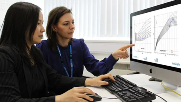 Clinical data researchers compare graphs on a computer screen