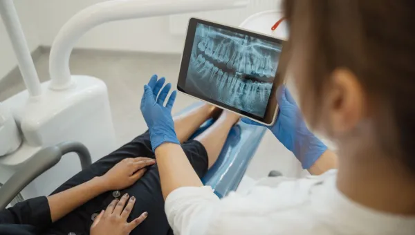 Dental professional and client in a consultation looking at an xray