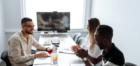 three people in discussion in business meeting room