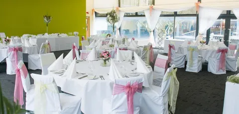 A pre-event photo of the Terrace Restaurant, decorated with wedding sashes on the chairs.