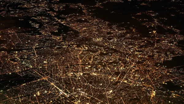Satellite image of a city showing nighttime activity highlighted by the lights along transport corridors and at points in the city