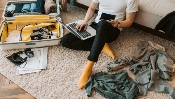 An international student packs their bag, including their passport, to come to the UK