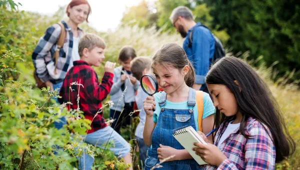 A group of children and two adults in the countryside