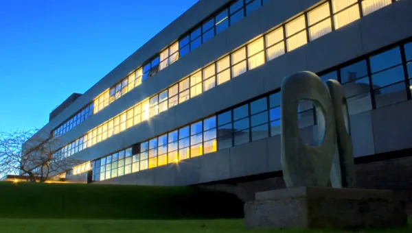 Highfield campus building 46 at dusk with lights shining from the windows