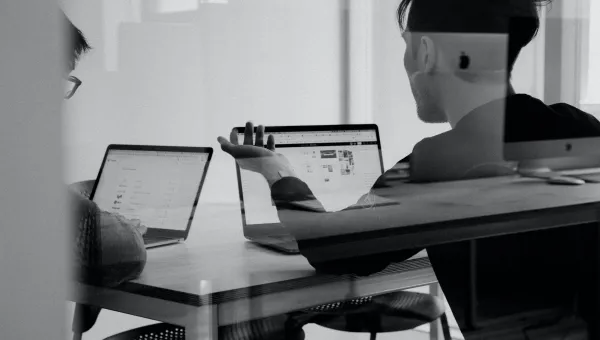 People working on laptops, seen through glass