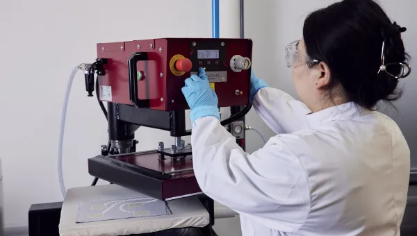 A woman researcher using a machine at the e-textile laboratory