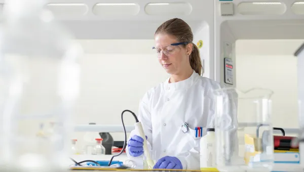 Scientist looking down and working with lab equipment